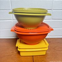Stacked view of the Tupperware containers showing four pieces with lids in green, orange, and yellow colors.