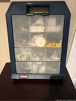 Front view of the Rubbermaid tool organizer showing closed transparent compartments with various small hardware inside.