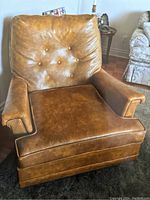 Front view of honey leather armchair showing button-tufted back cushion, seat cushion and armrests