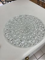 Top down view of clear brilliant pressed glass cake stand with Daisy and Buttons texture pattern, showing circular faceted design.