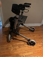Front-right side angled view of the Antar 14651 lightweight aluminum rollator walker showing wheels, frame, and padded seat.