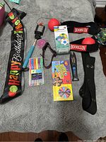 Photo showing full assortment of items including party sash, selfie stick, yoyo, markers, Bean Boozled game, reflex ball headgear, utility knife, dog leash, and boxed puzzle ball.