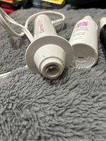 Close-up view of the top part of the Derma Wand device and one serum bottle.