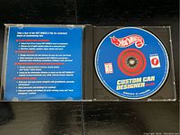 Open jewel case displaying Hot Wheels Custom Car Designer CD-ROM and instructions on the inside cover.
