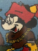 Close-up of the needlepoint showing Mickey Mouse's face and upper body in detailed stitching.
