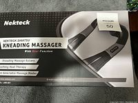 Front of the box showing product name 'Nekteck Shiatsu Kneading Massager with Heat Function' and key features like kneading rollers, heat therapy, and selectable massage modes.