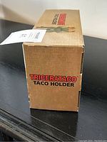 Box side view showing 'Tricerataco Taco Holder' branding on cardboard box