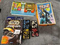 Photo showing unopened Star Wars collectible album in original packaging with visible wear, alongside Colorforms game pieces and The Fonz box.