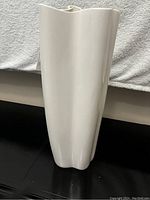 Tall white decorative vase, front and side views showing shape and glossy finish