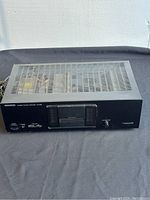 Front and top angled view showing the amplifier's black metal body with vented top and front controls.