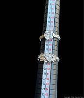 Top view of two silver rings placed on a measuring mandrel showing sizes about 8 and 6.5.