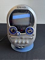 Front view of vintage Craig karaoke machine showing screen displaying lyrics, control knobs, and mic inputs