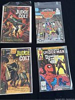 Four comics: two Judge Colt issues (1969, 1970), one Dominic Fortune (1982), one Booster Gold (1988) arranged in two rows