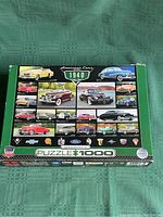Image of the puzzle box showing colorful illustrations of classic American cars from 1940 with the Cruisin Classics branding and 1000 piece count.