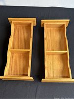 Front view of two wooden shelves side by side showing compartments and wood texture