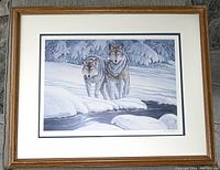 Framed limited edition print of two wolves in a snowy landscape by Bert Finan, showing the full image, matting, and solid wood frame.