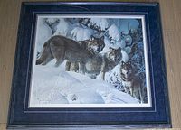 Full front view of framed print on floor showing wolves in snow scene