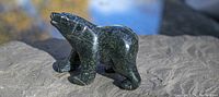 Front side view of black soapstone polar bear carving showing shape and texture