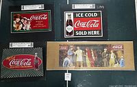 Four Coca Cola items including three metal collector signs with vintage advertisements and one boxed puzzle showing a Coca Cola social scene.