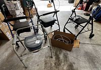 Three walkers, one with blue frame, one black, and one gray frame with portable toilet. Also shown is a cardboard box with shower head components.