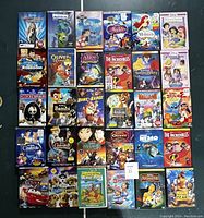 Front view of the entire collection of Disney children's DVDs arranged in rows on a dark background showing cover art of each movie.