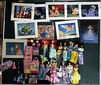 Overview photo showing all Disney Princess dolls, prints, mini figures, books, and CDs laid out on a surface.