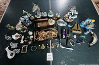 Photo showing a wide variety of dolphin figurines, brass sailing boot and boat, beaded necklaces, bracelets, wristwatches, key chains, miniature perfume bottles, and other small decorative items.