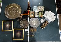 Lot overview showing brass tray, framed coins, wooden duck decoy, decorative plates, figurines, and various small collectibles
