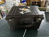 Closed black Pelican 1620 hard case with weather sealed latches and handle, shows wear and sticker residue.