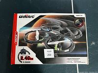 Closed retail box of Udi RC 2.4GHz 4-channel quadcopter drone showing product image and features.