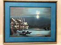 Full view of the framed oil painting showing moody waterscape with boats and reflection under a cloudy sky, framed in blue and gold.
