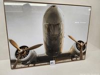Frontal view of the framed photograph showing vintage twin-engine airplane with wooden propellers, displaying the overall condition and detail.