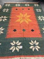 Full view of flatwoven kilim with central orange field and green border