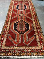Full-length view of the red and navy geometric runner on concrete floor
