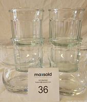 Stacked set of four faceted utility/drinking glasses with two rounded cocktail/whiskey glasses in front