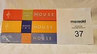 Three DVD box sets of House M.D. stacked horizontally, showing spine colors and season numbers with Universal logo visible. Season 1 remains unopened.