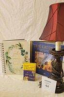 Photo shows the lamp with a burgundy facric shade, box of 101 Blessings, blank journal and The Gryphon book by Nick Bantock.