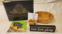 Photo of all items in the lot on a beige surface: black box, wooden bowl, ceramic coaster with cat, ceramic javelina figurine, wooden sign, soapstone animal figurine.