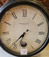 Close-up of clock face showing brand FirsTime & Co, Roman numerals and black hands on crackled white background.