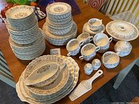 Full table view of American Limoges Lyric dinnerware set with plates, bowls, cups, and serving pieces arranged.