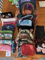 Overview of all bags and pouches including several fabric handbags, black beaded bag, small red handbag, and umbrella.