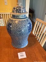 Front view of blue and white ceramic covered jar with lid on wooden table