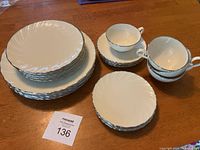Full set of all plates and cups and saucers arranged on a wood tabletop