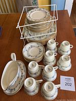 Overall view of stacked plates in three sizes, cups and gravy boat