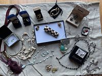 Complete lot of assorted costume jewelry displayed on fabric surface showing all items together