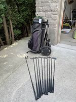 Wide shot showing golf bag on carrier and clubs in bag and on ground