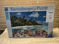Photo of Ravensburger 2000 piece puzzle box showing tropical coral reef and palm tree scene.