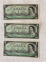 Front side of three uncirculated Canadian one dollar bills stacked vertically showing Queen Elizabeth II portraits and commemorative Centennial text.
