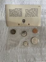 Five uncirculated Canadian coins from 1966 including 1 cent, 5 cent, 10 cent, 25 cent, and 50 cent pieces accompanied by a certificate of authenticity on a white fabric background.
