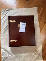 Closed wooden keepsake box showing the top with brass-colored hinge accents and metal name plate.